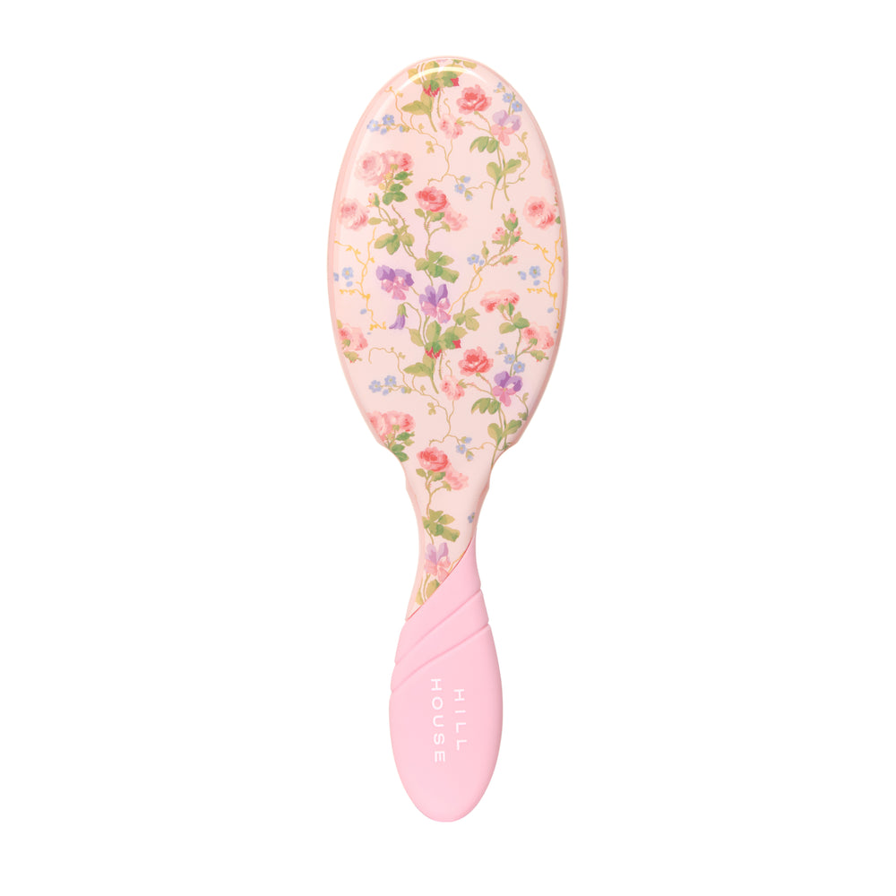 Pink hairbrush with floral pattern on a white background